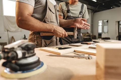 Two carpenters working together at a workshop Stock Photos