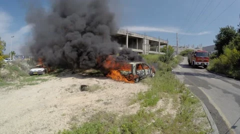Two cars explode and burn after rocket attack, some injured Stock Footage 53438684