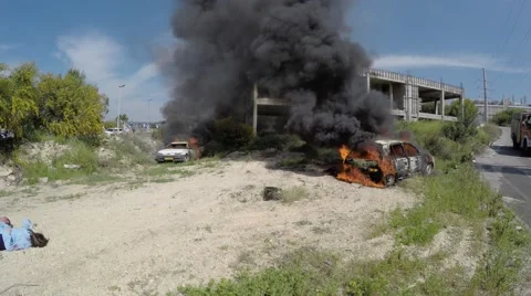 Two cars explode and burn after rocket attack, some injured  Stock Footage 53439582
