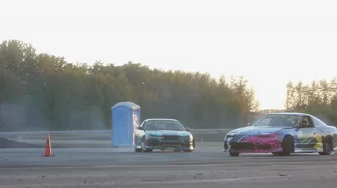 Two cars race side by side around corner on drift racing track. Video stock 59762068