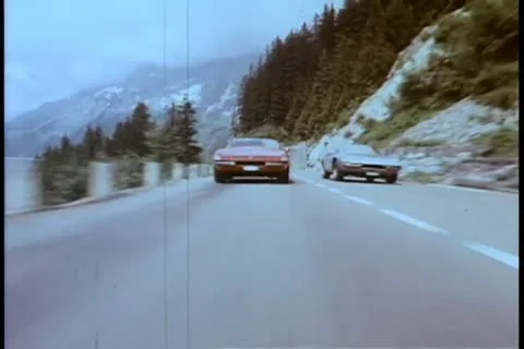 Two cars speeding through mountainside highway Stock Footage 11348844
