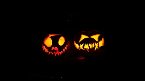 Two Carved Jack-o'-Lanterns Glowing in Complete Darkness Halloween Vídeo Stock 342563541