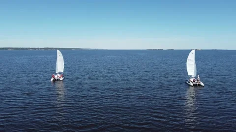 Two catamarans under sail at sea. Blue sky, blue water surface with ripples Stockbeeldmateriaal 197181725