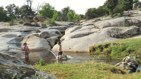 Two Caucasian children bathing in a river in summer Stock Footage 277101293