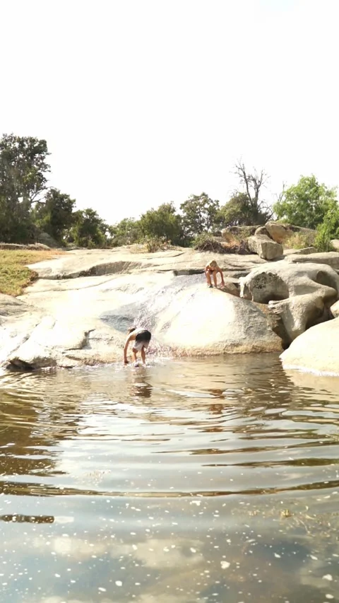 Two Caucasian children bathing in a river in summer Stock Footage 277194320