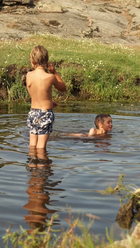 Two Caucasian children calmly bathing in the river in summer Stock Footage 277453985