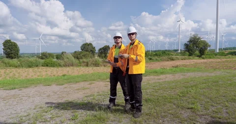 Two caucasian engineers using drone and tablet check turbine efficiency outdoor Stock Footage 337163775