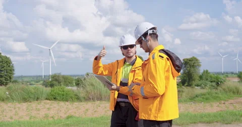 Two caucasian engineers wearing orange jackets analyze data from drone Stock Footage 325845819