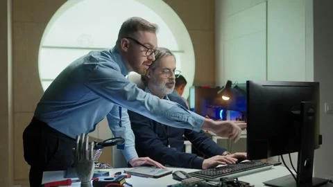 Two Caucasian engineers working together on project or creating innovative Stock Footage 241236260