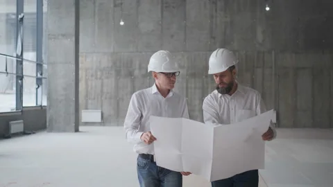 Two Caucasian Handsome Men In Helmets Talking And Looking At The Big Paper With Stock Footage 106991954