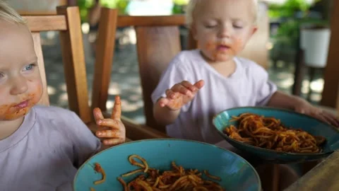 Two caucasian learining to feed themselves - eating healthy tomato pasta with Stock Footage 159936668