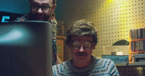 Two Caucasian males nerds in front of PC monitor and watching something Stock Footage 135626557