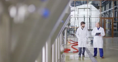 Two Caucasian mans working at a brewery factory. A male brewer checks the Video stock 147950248