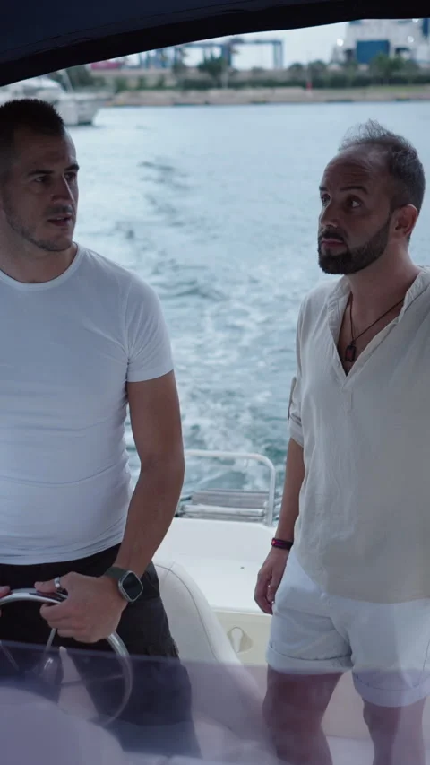 Two caucasian men are talking about something while the boat is moving Video stock 264924312