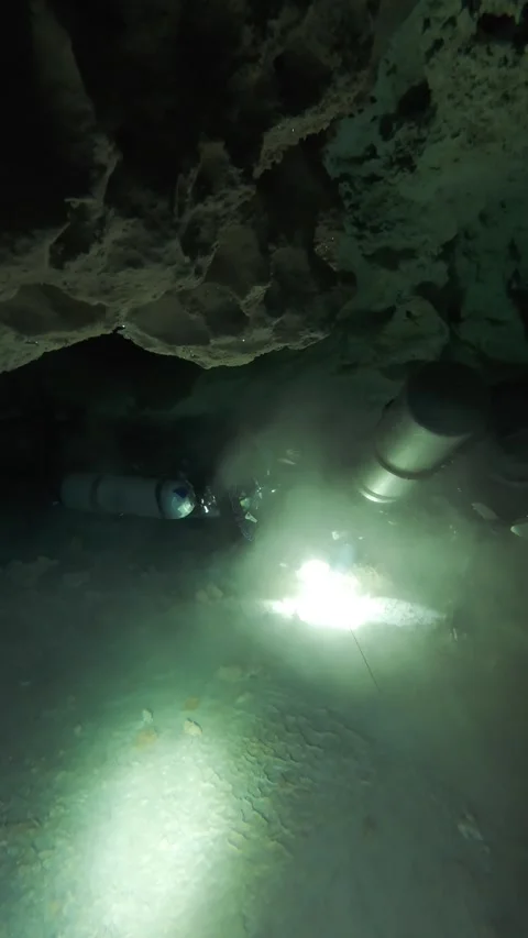 Two cave divers communicate in an underwater cave Stock Footage 277230233