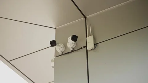 Two CCTV cameras installed under the ceiling in a modern office. Stock Footage 314197254