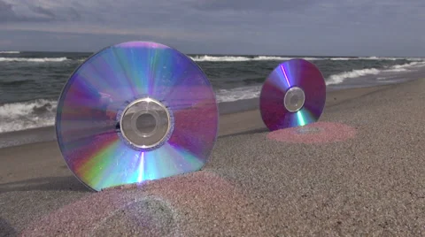 Two CDs on sea beach sand and waves Video stock 54807785