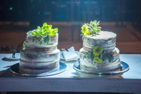 Two celebratory cake on a table. Night scene. Stock Photos
