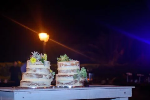 Two celebratory cake on a table. Night scene. Stock Photos