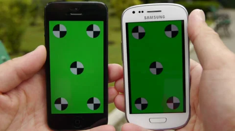 Two Cell Phone, touch screen, held by hands. Comparison. Green screen Chroma Key Stock Footage 33311473
