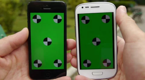Two Cell Phone, touch screen, held by hands. Comparison. Green screen Chroma Key Stock Footage 33311931
