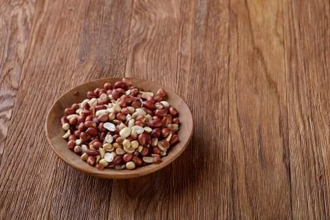 Two ceramic bowls with raw peanuts mix isolated over rustic wooden backround Stock Photos