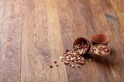 Two ceramic bowls with raw peanuts mix isolated over rustic wooden backround Stock Photos