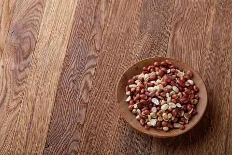 Two ceramic bowls with raw peanuts mix isolated over rustic wooden backround Stock Photos