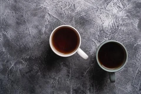 Two ceramic cups with black tea, hot drink in white and grey cup Stock Photos