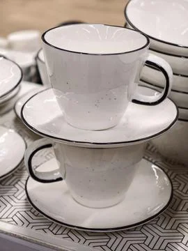 Two ceramic cups on saucers stacked neatly creating a minimal kitchenware c.. Stock Photos