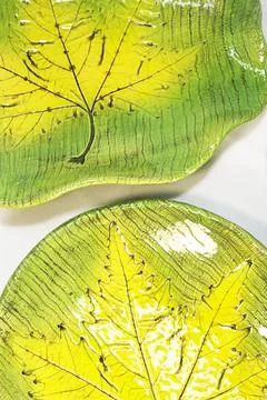 Two ceramic plates with leaf imprint yellow and green Stock Photos