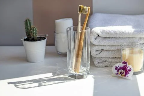 Two ceramic toothbrushes cling to each other, glare from the sun on a white Stock Photos