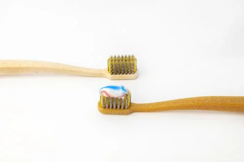 Two ceramic toothbrushes, on one of them applied colored toothpaste, on a white Stock Photos