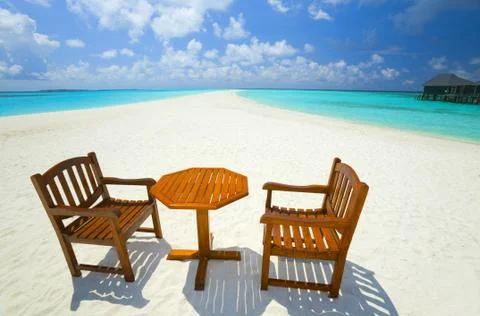 Two chairs and one table are on the coral sandy beach, Maldives 스톡 사진