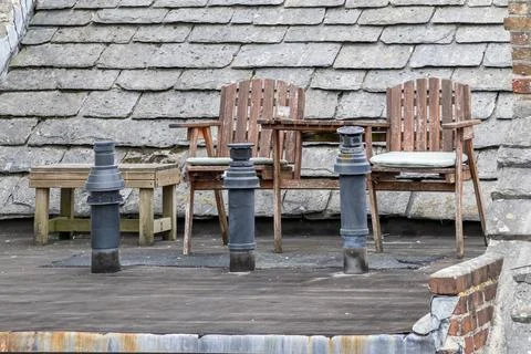 Two chairs and a table on top of an old slate rooftop Stock Photos