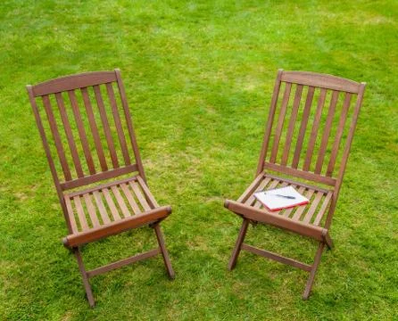 Two chairs with notebook in garden Stock Photos