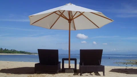 Two chairs under an umbrella on a beach Stock Footage 267184928