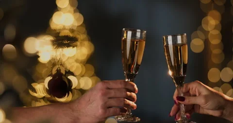 Two champagne flutes clinking against blurred Christmas tree Stock Footage 320073452