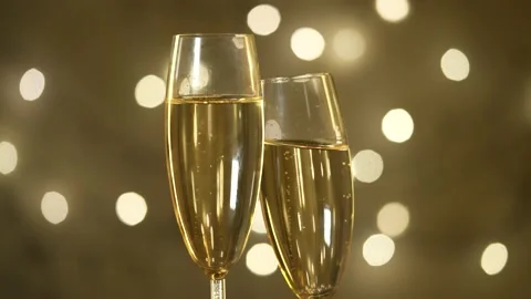 Two champagne glasses. Background is a glowing garland Slow motion. Stock Footage 231795046