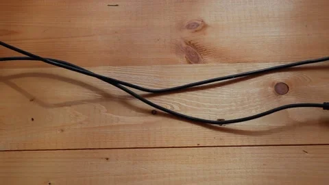 Two charging units on wires are slowly dragging on the wooden floor Vídeo Stock 147084619