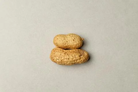 Two charming peanuts resting on a soft, neutral background Stock Photos