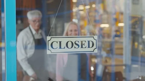 Two cheerful aged small business owners smiling while putting open sign at cafe Stock Footage 135229229