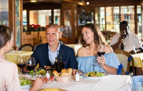 Two cheerful couples having dinner and nice talking Stockfoto's