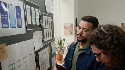 Two Cheerful Male UX Developers Discussing Wireframe Concepts on Project Board Stock Footage 327906763