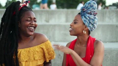Two cheerful women having a discussion while sitting outdoors Stock Footage 161742353