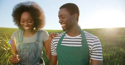 Two cheerful workers in the field communicating and laughing together while Stock Photos