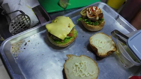 Two Cheeseburgers Being Assembled at Thai Street Food Stall with Melted Cheese Stock-Footage 330571386