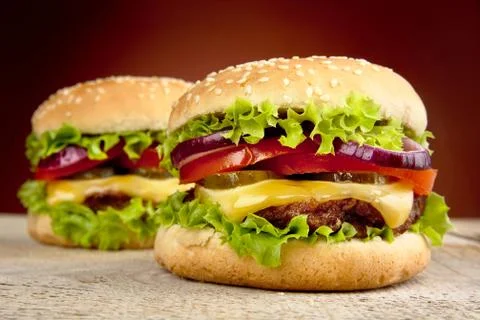 Two cheeseburgers on burned background Stock Photos