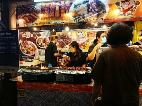 Two chefs are preparing Indonesian satay at Jakarta local food festival Stock Photos