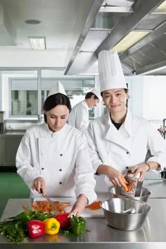 Two chefs doing prep work in a commercial kitchen Stock Photos